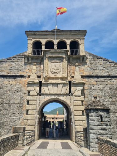 Entrance to the historic Citadel of Jaca, with the Spanish flag above the stone gateway, visited during a Valle de Tena Explorer walking holiday.